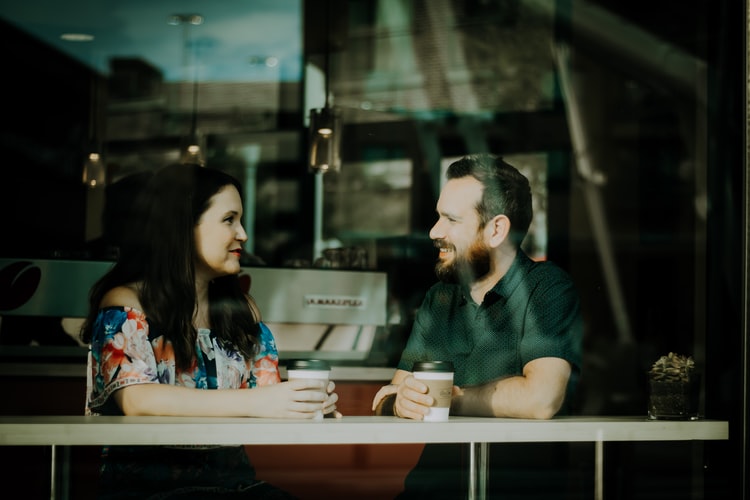 Two people talking over coffee